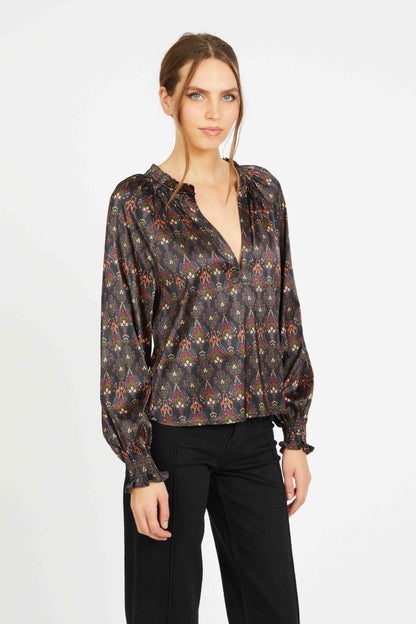 Angled view of the Vickie Top showcasing its fluid satin drape, earthy medallion print, V-neckline, and romantic puff sleeves with ruffled cuffs.