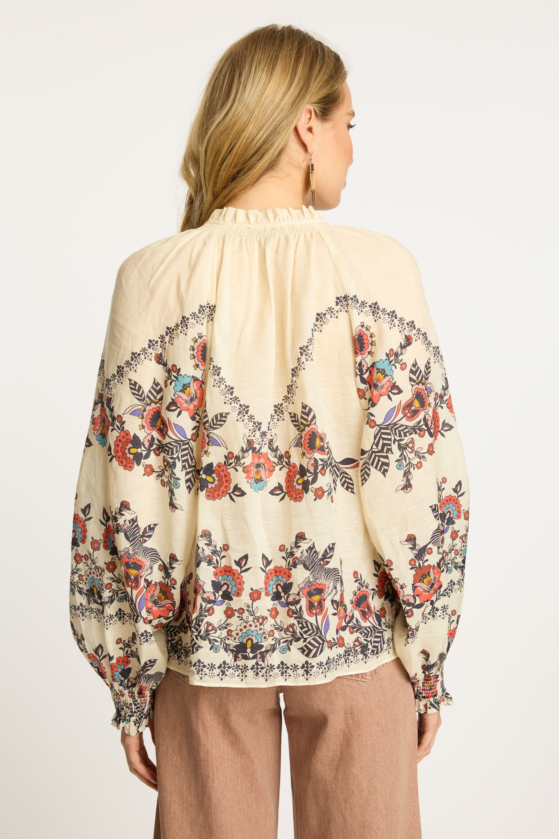 Back view of the Vickie Top in Zebra Leaf highlighting the embroidered floral details, gathered neckline, relaxed fit, and voluminous sleeves.
