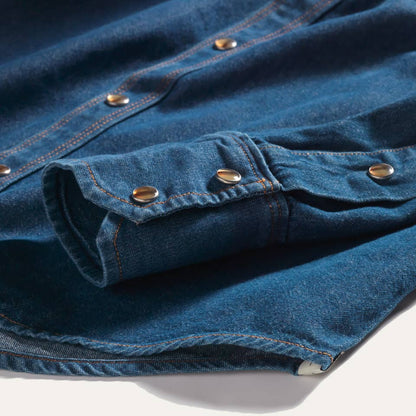 Close-up detail of the Western Snap Shirt in Washed Chambray showing faux tortoise snap buttons, contrast stitching, and soft washed cotton chambray fabric.
