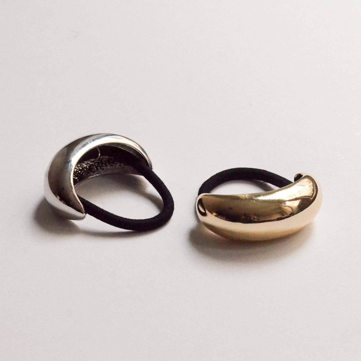 Gold and silver wide crescent metal ponytail hair ties displayed side by side.