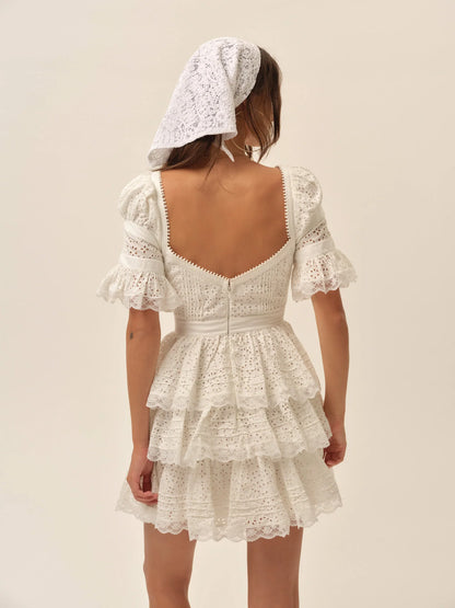 Back view of the Willa Mini Dress in white with puff sleeves, fitted bodice, lace trim details, and layered ruffle mini skirt.