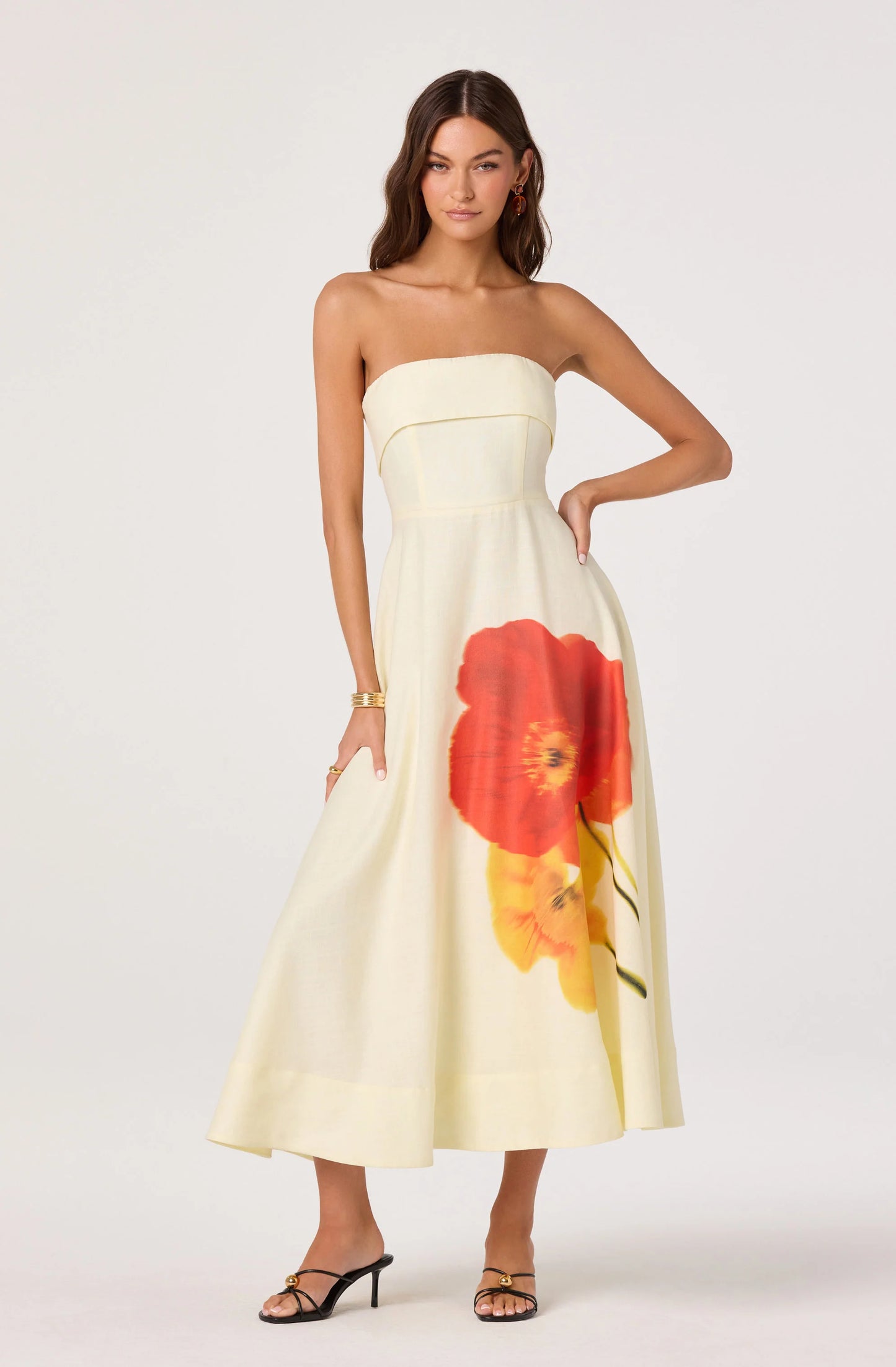 Front view of the Ximena Floral Strapless Midi Dress featuring a cream A-line silhouette with bold red and yellow floral placement print.