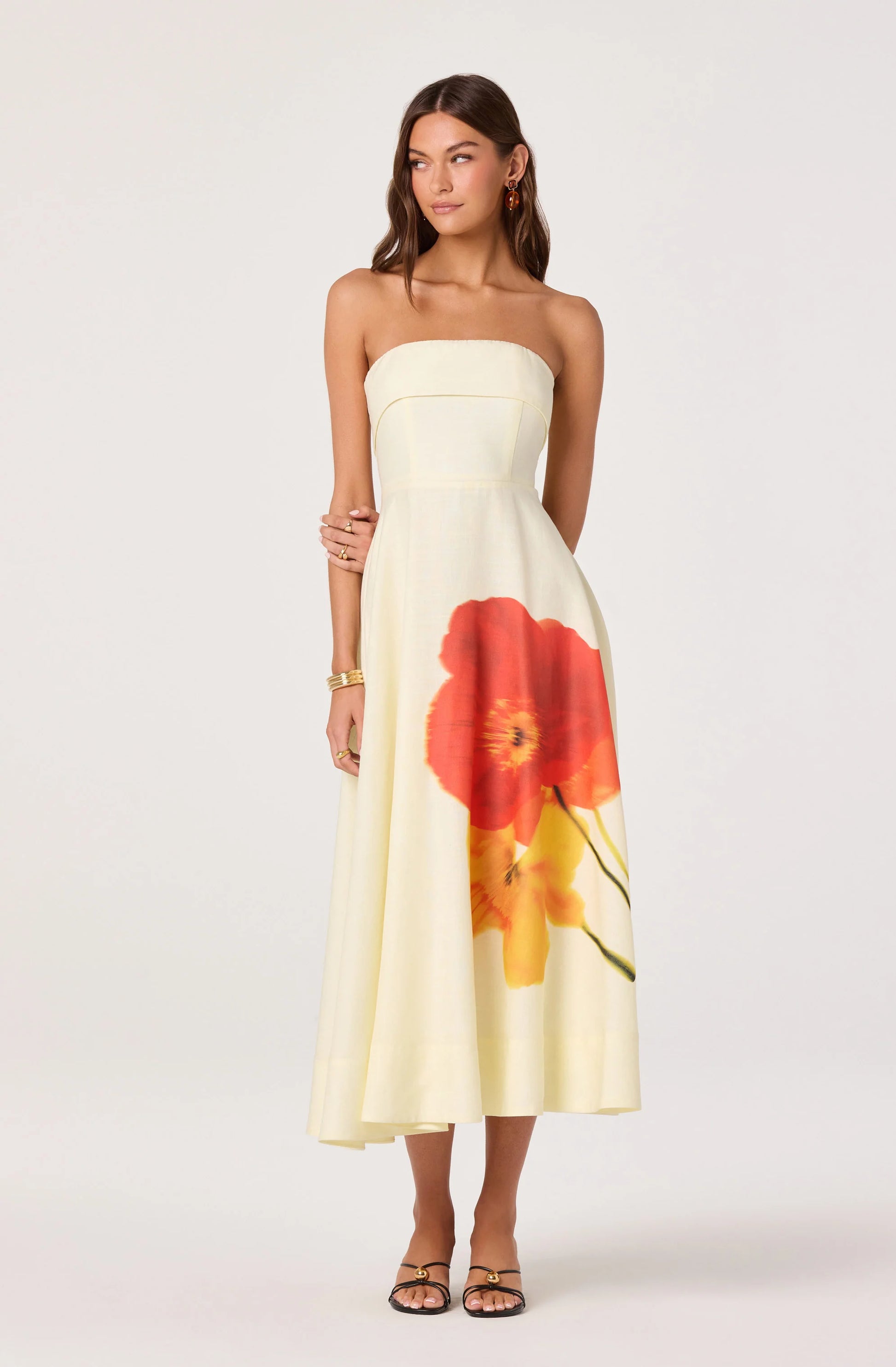 Model wearing the Ximena Floral Strapless Midi Dress with a fitted strapless bodice, A-line skirt, and bold floral print at the front.