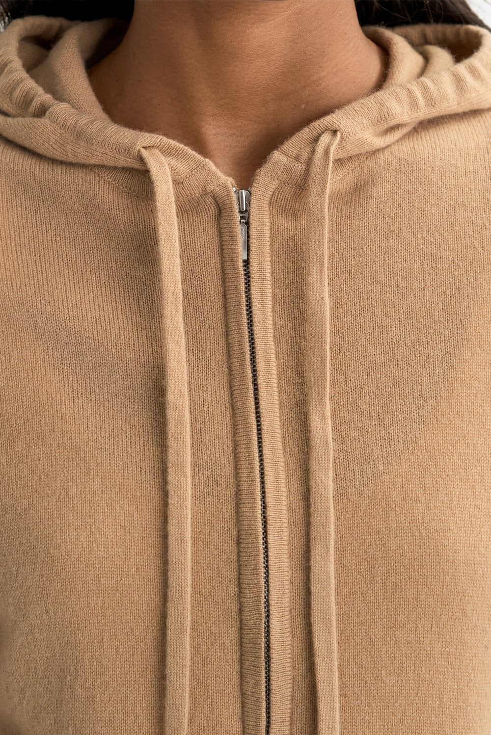 Close-up of the camel cashmere knit fabric, drawstring hood, and front zip closure