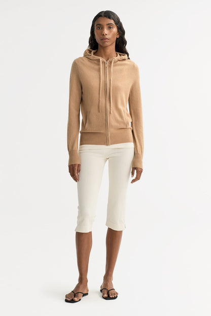Model wearing a camel cashmere zip hoodie with cropped cream trousers for a refined casual look