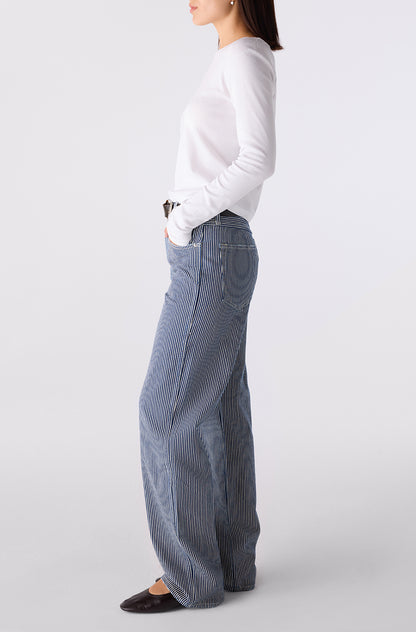 Woman wearing the Little Rowdy Annette Jean in blue and ivory striped denim, side view