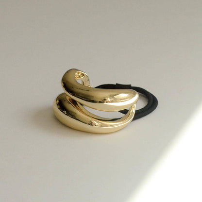 Sculptural gold ponytail cuff with layered curved-loop design