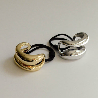 Gold and silver wide sculptured metal ponytail hair ties shown together